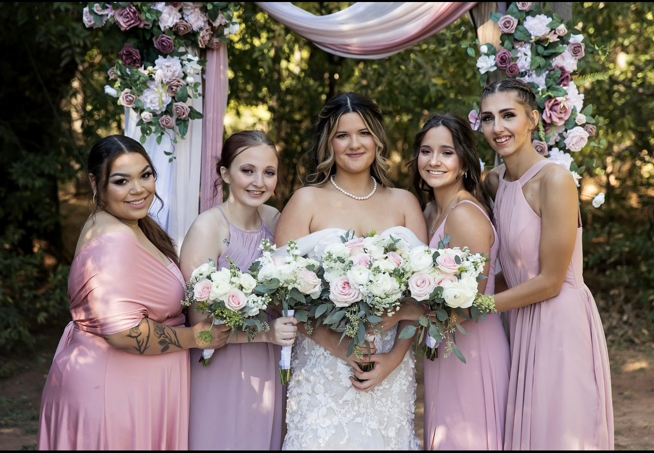 Wedding floral arch with bridesmaids