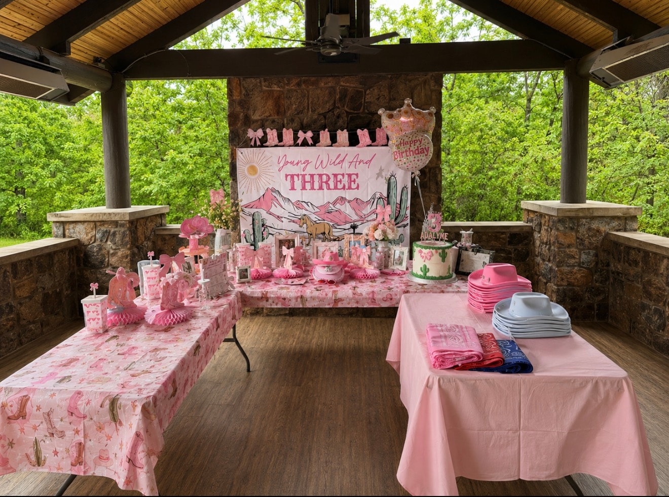 Young Wild and Three pink western birthday party setup under pavilion